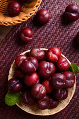 Fresh Japanese or Chinese plum fruit in bamboo basket, Top view