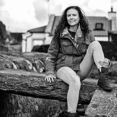Portrait of a lady seated on an ancient rock slab bridge