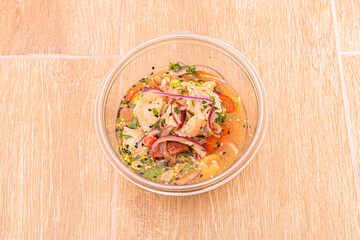 Fish ceviche with a lot of marinated liquid with red onion and tomato