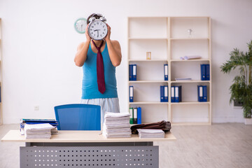 Young male employee coming to work straight from bed