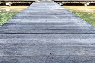 Old wooden bridge walkway across the canal in the summer garden