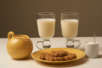 Healthy fresh milk and cookies, on white table and dark background.