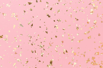 Gold confetti sparkles on pastel pink background, golden foil, chic holidays.