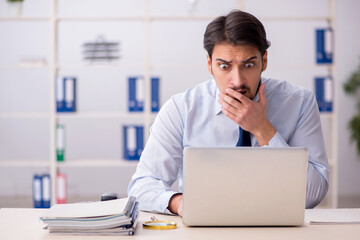 Young businessman employee unhappy with excessive work in the of