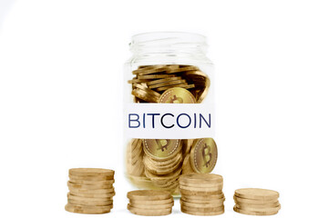 Glass jar full of golden coins with Bitcoin word