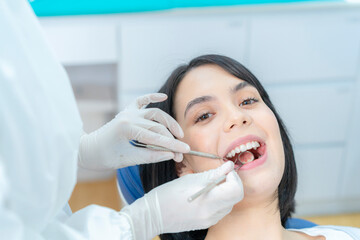 Portrait of Caucasian patient getting tooth checkup in dental clinic.