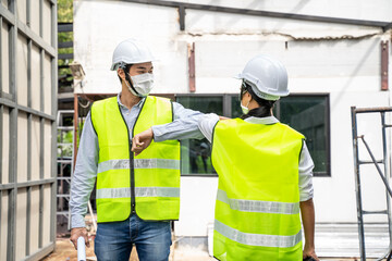 Asian architect or engineer team greeting each other by elbow bump.