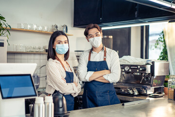 Portrait of Asian waiter and waitress wearing face mask, crossing arms