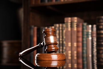 Law theme. Judge chamber. Judge’s gavel and collection of legal books in the bookshelf.