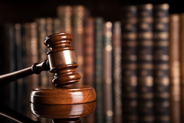 Law theme. Judge chamber. Judge’s gavel and collection of legal books in the bookshelf.