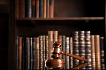 Law theme. Judge chamber. Judge’s gavel and collection of legal books in the bookshelf.