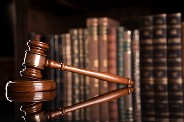 Law theme. Judge chamber. Judge’s gavel and collection of legal books in the bookshelf.