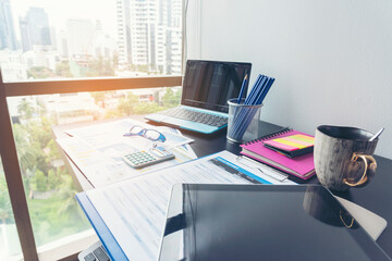 Office laptop business financial document chart and graph on wooden table with coffee cup. Flat lay notebook computer laptop on office desk. No people business graph chart mockup on business workspace