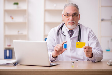 Old male doctor in credit card payment and vaccination concept