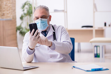 Old male doctor working in the clinic