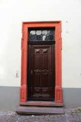 A dark brown wooden door with an old antique design