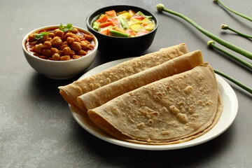 Homemade delicious whole wheat chapati served with chickpeas ,masala curry, Indian  traditional foods background,