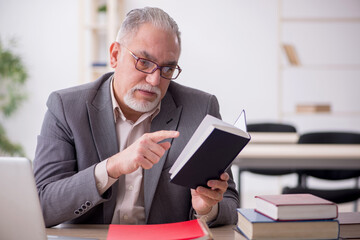 Aged male teacher in the classroom
