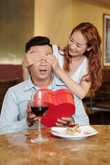 Pretty young woman making romantic surprise for her boyfriend on Valentines day