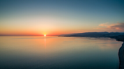 Obraz premium Sunset over a calm sea from the height of bird flight
