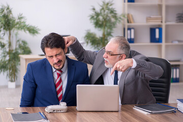 Two male employees working in the office in bullying concept