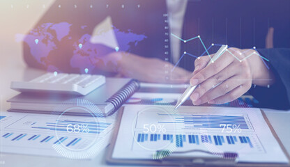 Financial Businesswomen analyze the graph of the company's performance to create profits and...