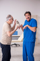 Obraz premium Old male patient meeting young male doctor in expensive medicine