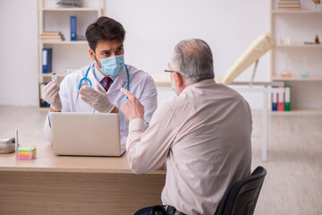 Fototapeta premium Old male patient visiting young male doctor in vaccination conce
