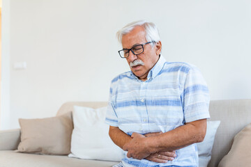 Old man having strong abdominal ache, health problems. Senior man with stomach pain