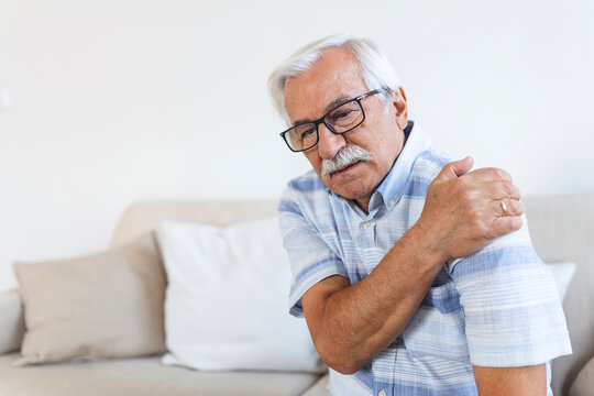 Old senior man with shoulder pain. Upset senior elder man feel sudden back pain muscles ache tension injury at home, grandfather touching shoulder having osteoarthritis arthritis