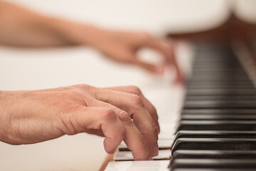 Fototapeta premium Close-up of hands playing the piano.