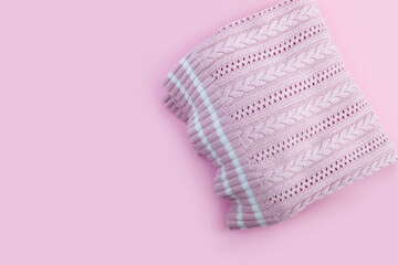 Woolen knitted pink sweater on paper background.