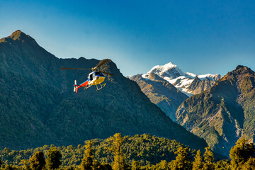 Chopper lifting off the ground on the West Coast of New Zealand heading for the glaciers in the...