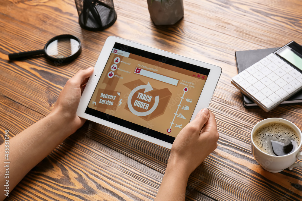 Poster woman holding tablet computer with open page of delivery service application on table