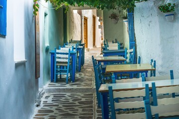 Greckie podwórko z kolorowymi meblami i kamienną posadzką - obrazy, fototapety, plakaty