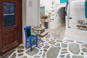 Greckie podwórko z kolorowymi meblami i kamienną posadzką