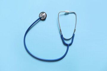 Modern stethoscope on color background