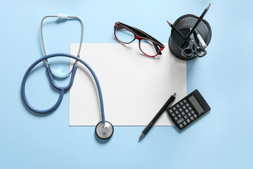 Composition with modern stethoscope, eyeglasses and sheet of paper on color background