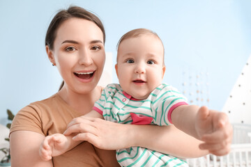 Happy mother with cute baby at home, closeup