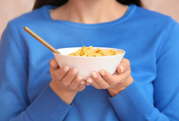 Young woman and bowl with cornflakes, closeup