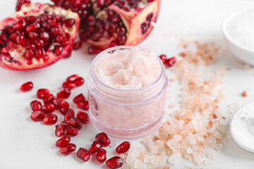 Composition with body scrub, sea salt and pomegranate on light background