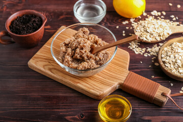 Bowl of natural body scrub and ingredients on wooden background