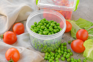 Plastic containers with vegetables on grey background, closeup