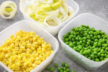 Plastic containers with vegetables on grey background, closeup
