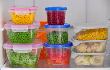 Plastic containers with vegetables in refrigerator