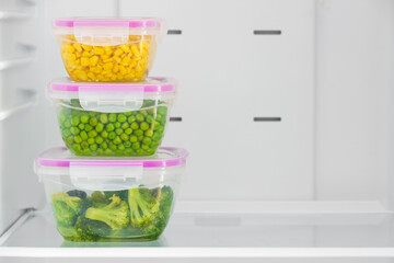 Plastic containers with vegetables in refrigerator