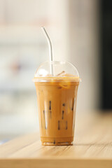 Cup of tasty iced coffee on table in room, closeup