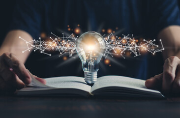 Book or textbook and glowing light bulb. Self learning or education knowledge and business studying...
