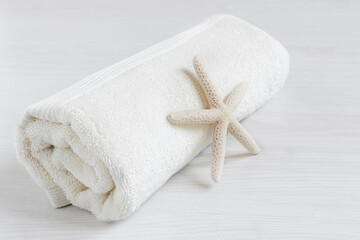 Obraz na płótnie Canvas Towel with starfish on white wooden table.