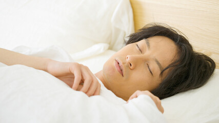 Fototapeta na wymiar ベッドで眠る男性